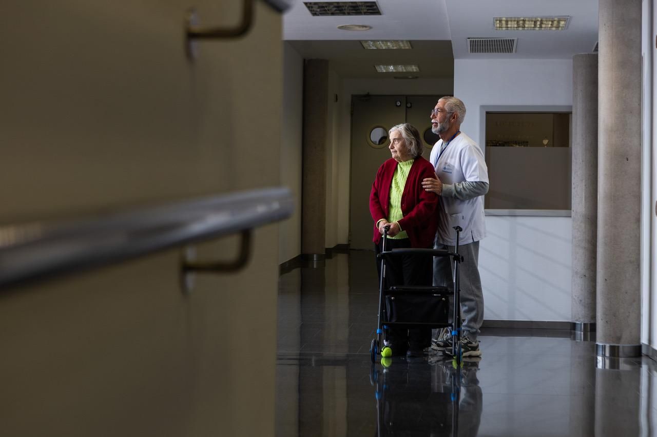 Juanjo acompaña a Rosa por el pasillo, paso a paso, apoyada en el andador