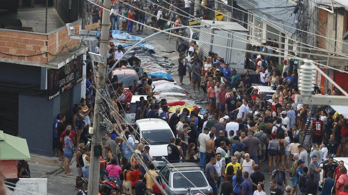 Un grupo de personas observa los cuerpos sin vida en una calle de Río de Janeiro (Brasil).