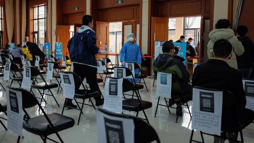Varias personas hacen cola para ser vacunadas contra la COVID-19 en un centro de vacunación en Pekín, China.