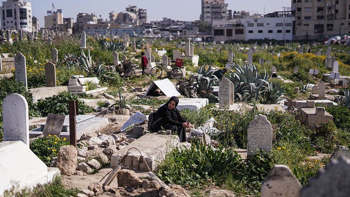 Una mujer visita la tumba de sus seres queridos en un cementerio de Ciudad de Gaza, el 20 de marzo de 2026.