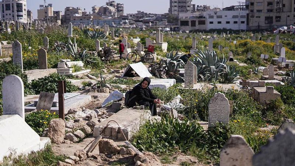 Una mujer visita la tumba de sus seres queridos en un cementerio de Ciudad de Gaza, el 20 de marzo de 2026.