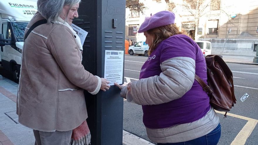 Unas trabajadoras pegando carteles durante la marcha.