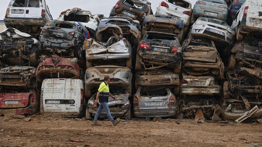 Varios coches, que fueron arrastrados por el agua tras el paso de la DANA, almacenados en un descampado en Paiporta este viernes.