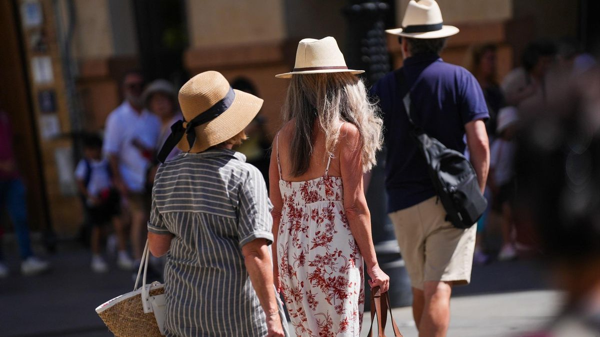 Turistas con ropa veraniega paseando por el casco histórico de Sevilla.
