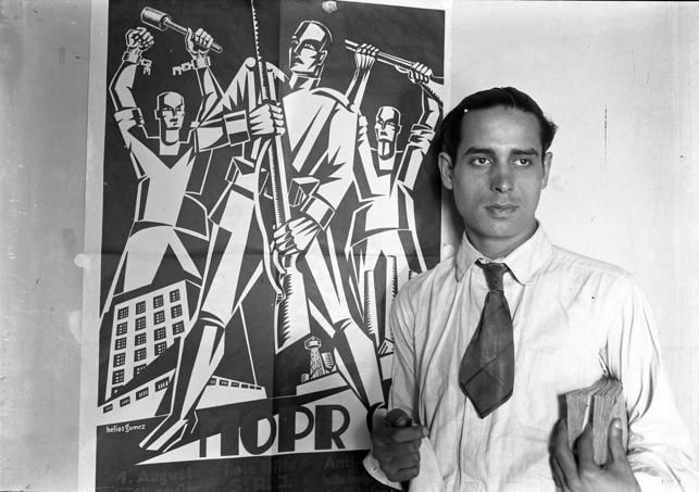 El pintor Helios Gómez frente a uno de sus retratos 