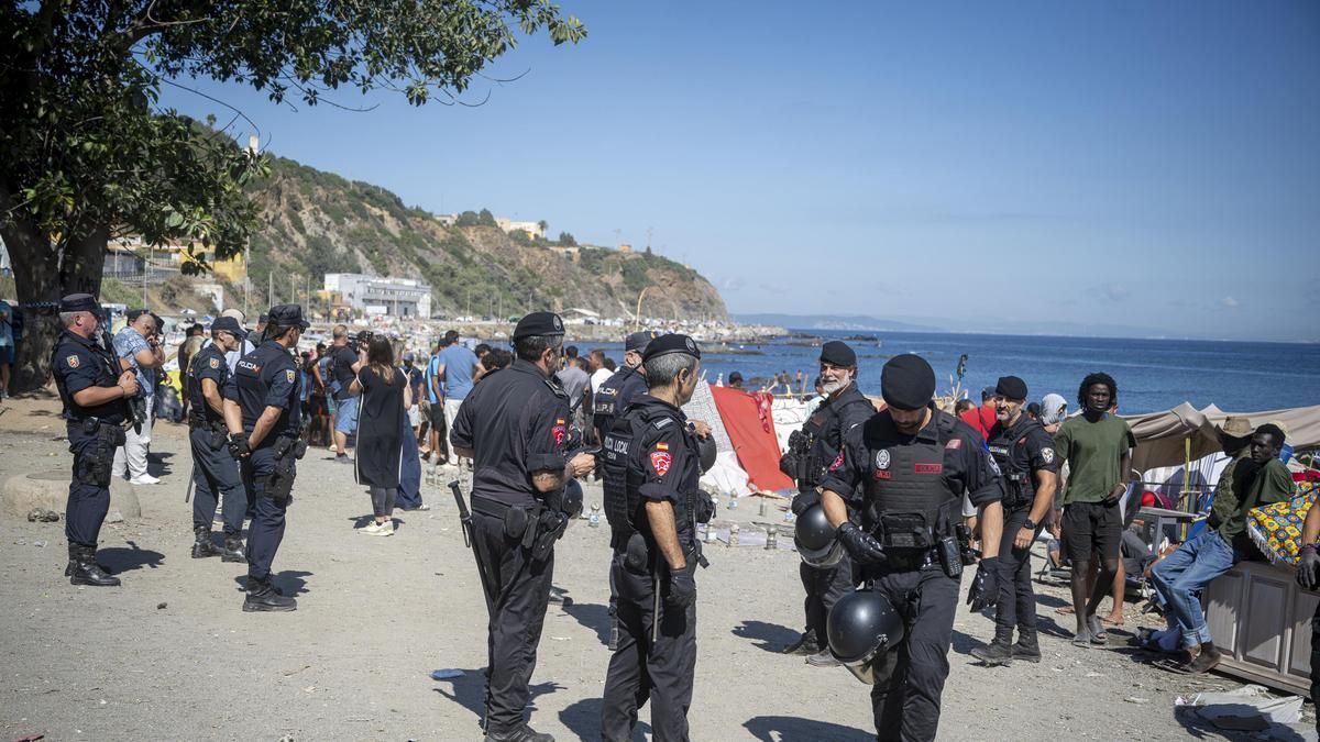 Un grupo de policías tras desmantelar un mercadillo organizado por los migrantes de la playa de El Trampolín esta semana.