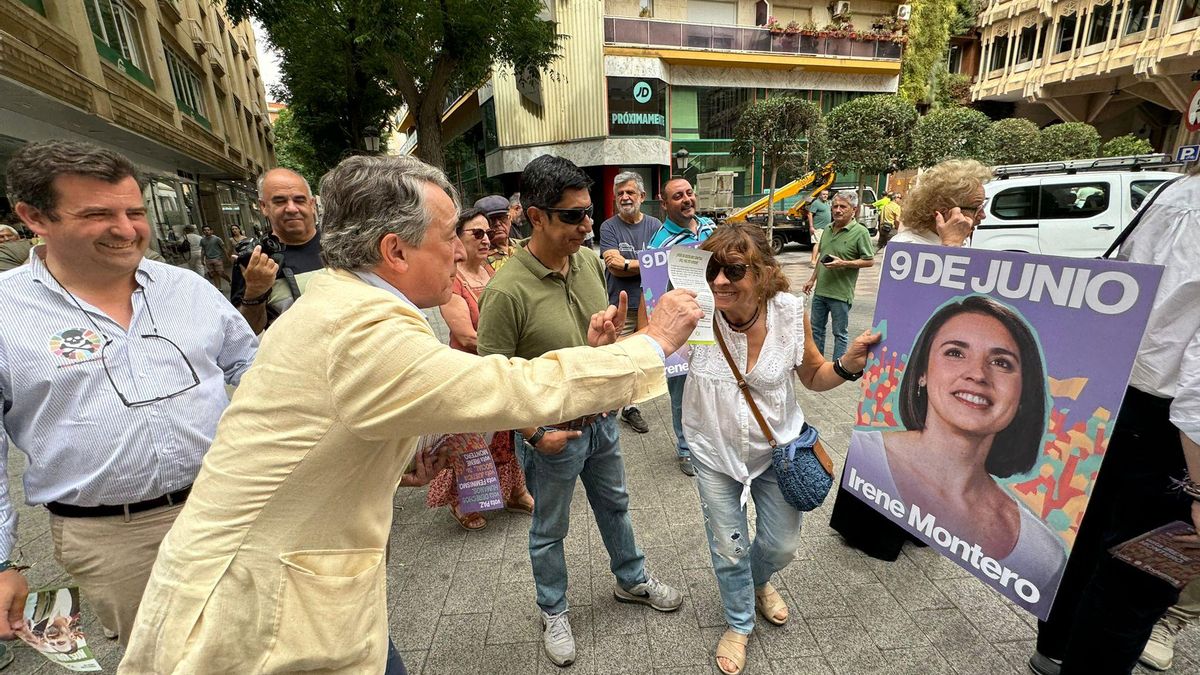 Herman Terstch ofreciendo propaganda electoral de Vox ante un cartel de la cabeza de lista de Podemos, Irene Montero