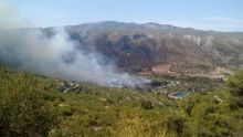 Un avión trabaja en las tareas de extinción del fuego en la Vall de la Gallinera