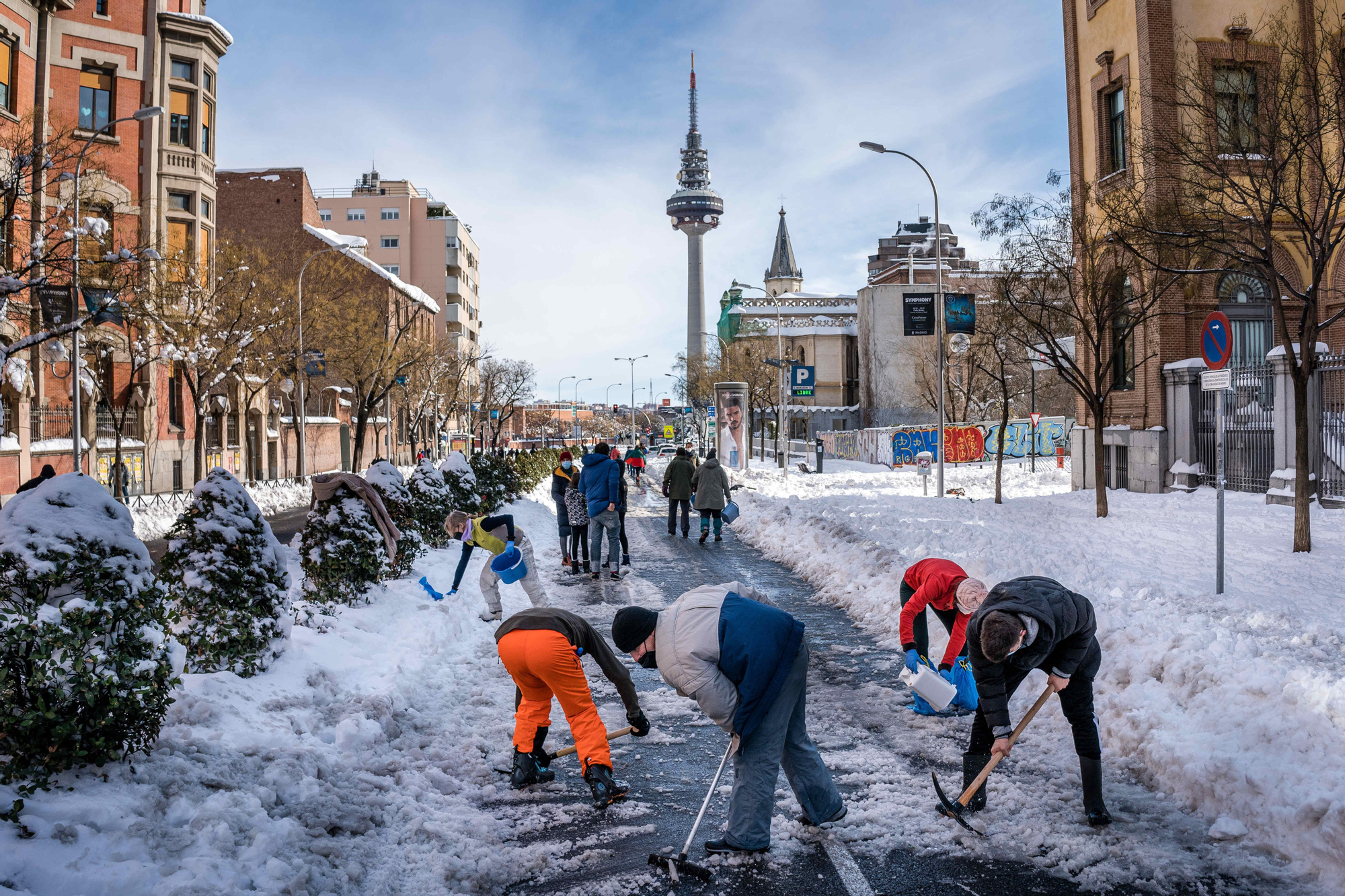 Vecinos de Madrid limpian de nieve la calle O'Donnell donde está el Hospital Materno Infantil.