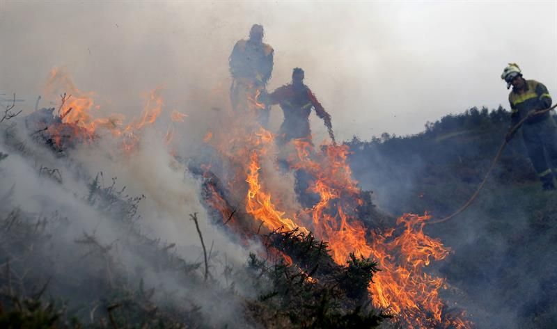 Efectivos del servicio de Bomberos durante las labores de extinción del incendio producido en la parroquia de Cures, Boiro (A Coruña, Galicia), en la Sierra del Barbanza.