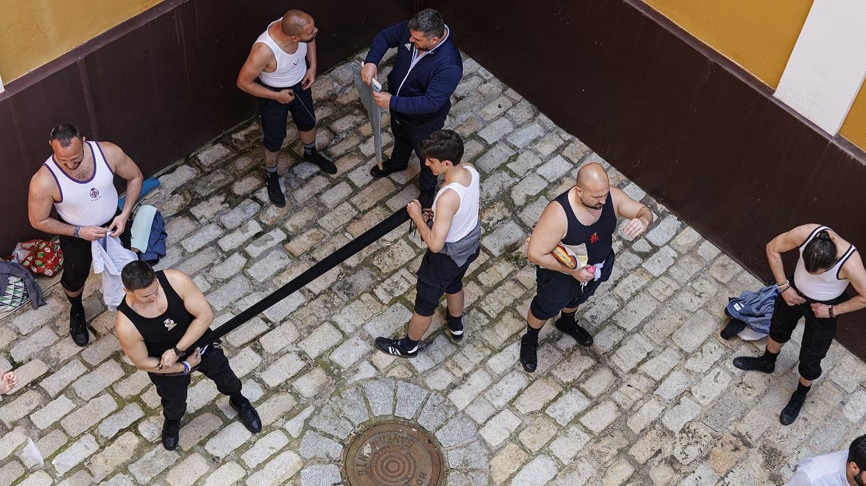 Costaleros reliándose la faja.