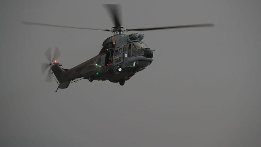 Momento en el que un helicóptero Superpuma, perteneciente al Ala 46 del Ejército del Aire, ha realizado una ofrenda floral por todos los difuntos en un punto de la colada cercano al Cementerio de Las Manchas, donde han soltado pétalos.