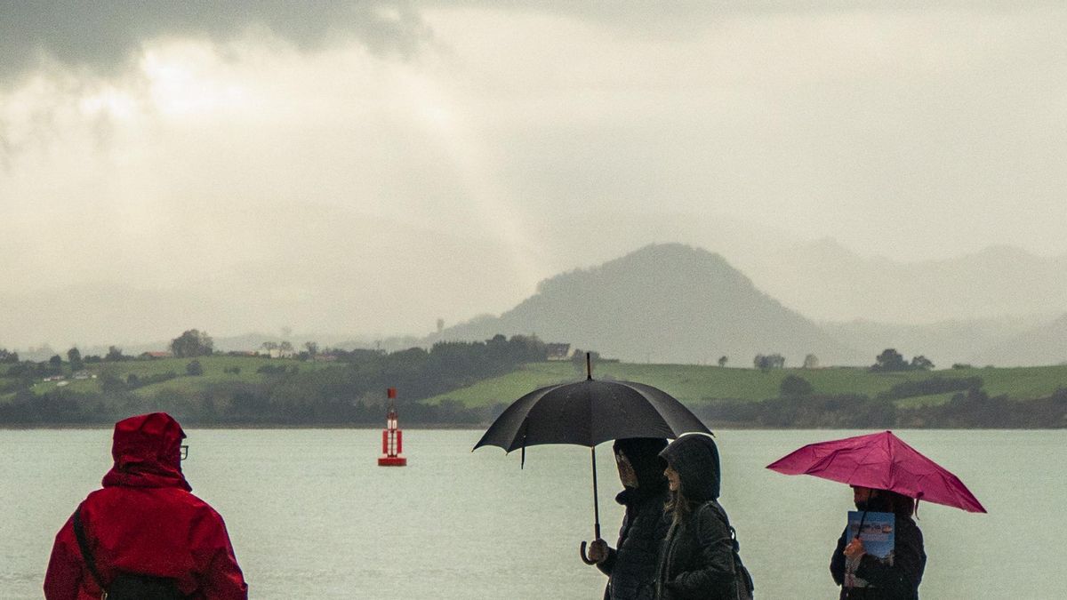 Gente pasea bajo la lluvia en imagen de archivo.