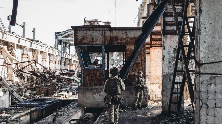 .Dos soldados, del ejército ucraniano, caminan por una antigua fábrica destruida por la guerra en la línea del frente, a 19 de febrero de 2022