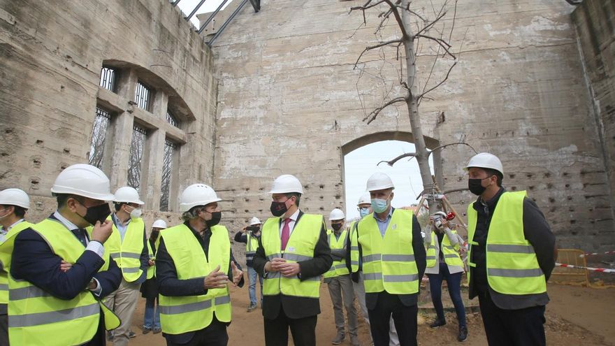 Juan Espadas, en el centro, ante la higuera que ha crecido en el interior de las naves.