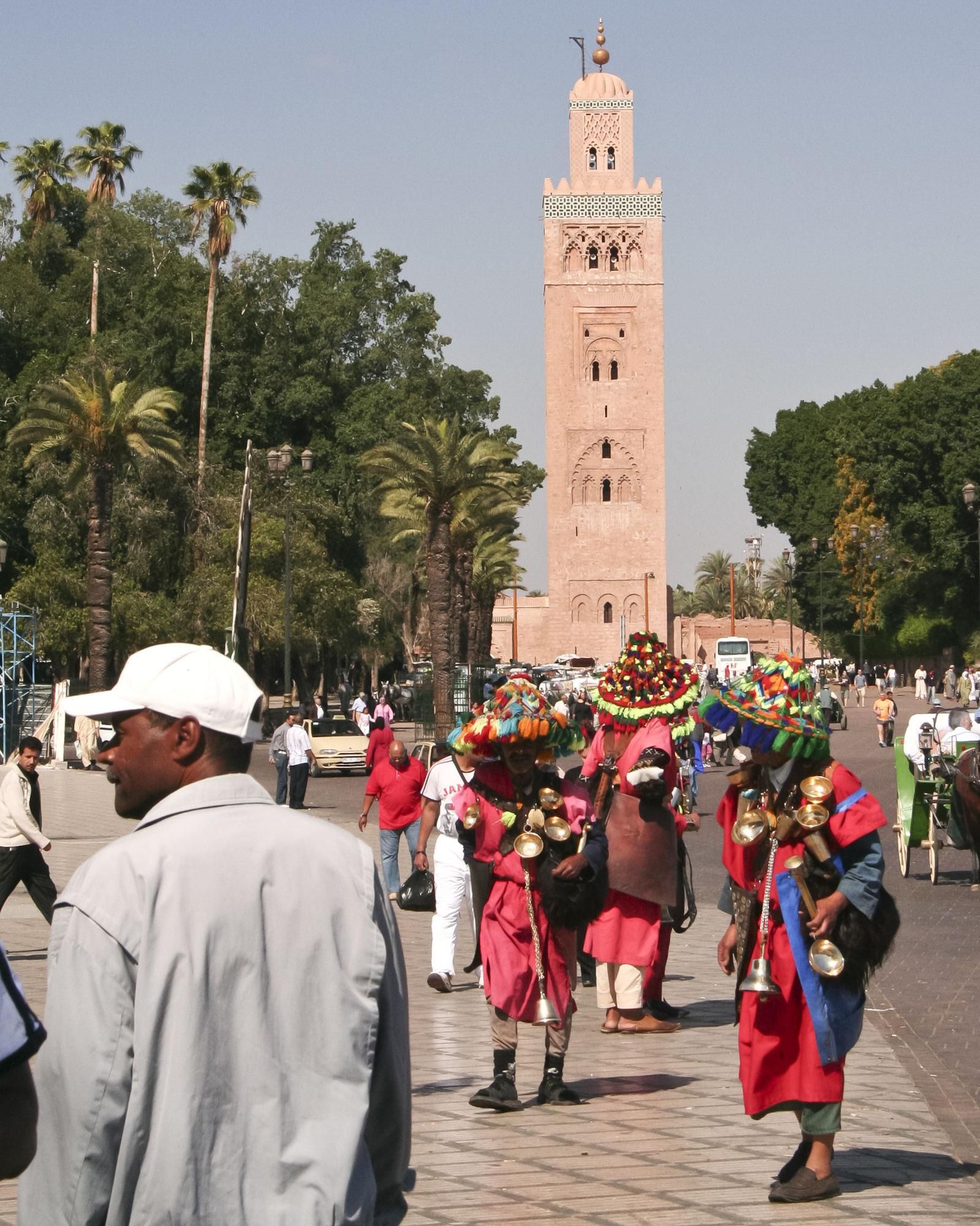 Aguadores en Jemaa El Fna. Al fondo puede verse el minarete de La Koutubia.