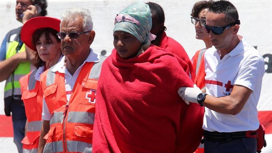 Un voluntario de Cruz Roja atiende en el muelle a algunos inmigrantes rescatados la semana pasada en el sur de Gran Canaria.