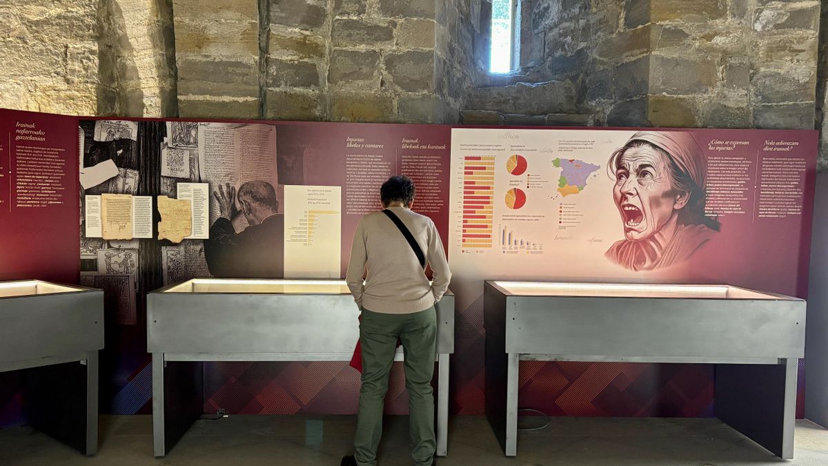 Una visitante observa uno de los paneles de la exposición "Insultos de otro tiempo" en el Archivo General de Navarra.