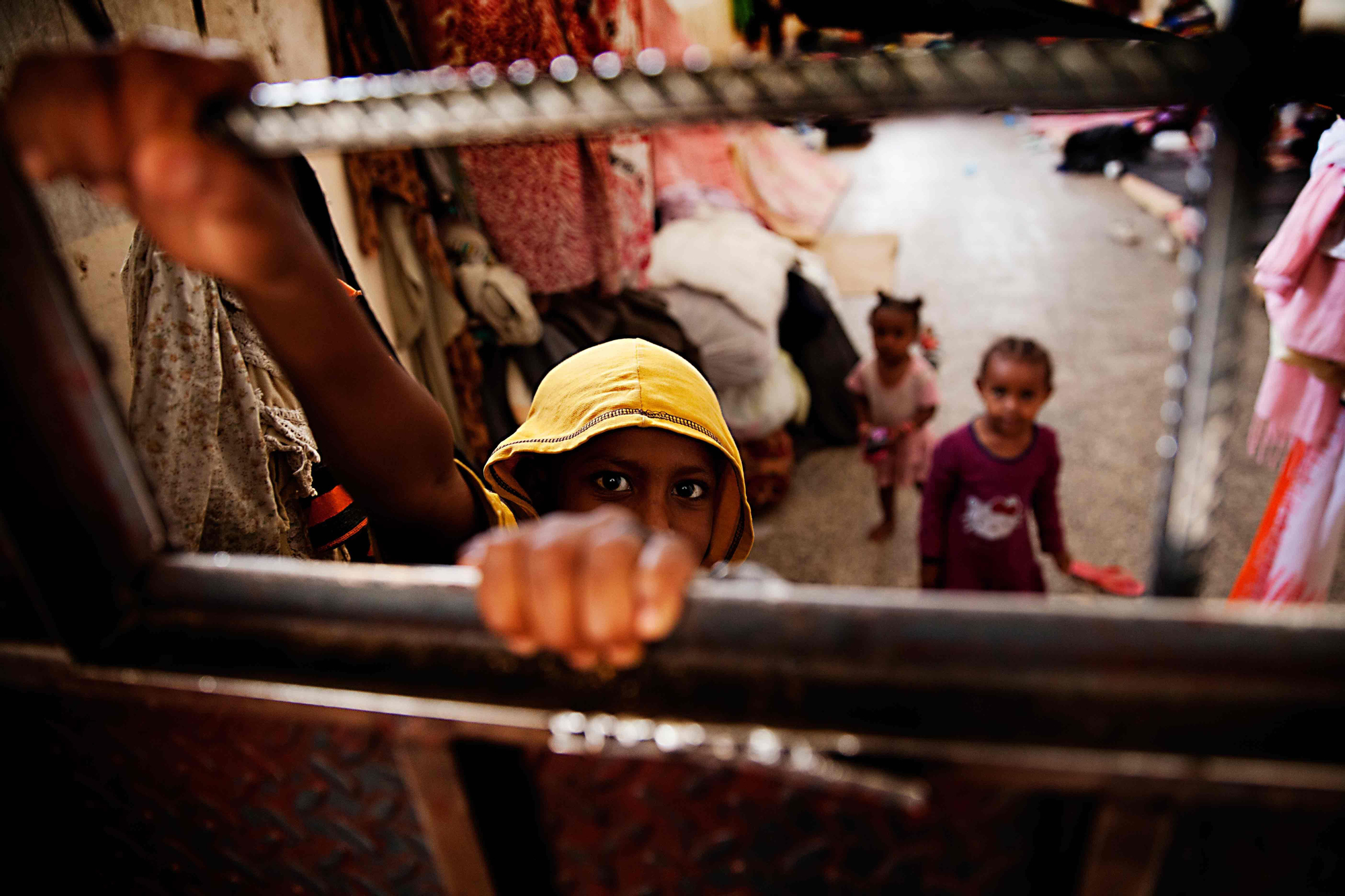 Niños retenidos en el centro de detención de inmigrantes de Saná trata de elevarse para mirar por la pequeá ventana de la puerta de su celda. / Copyright: Anna Surinyach/MSF