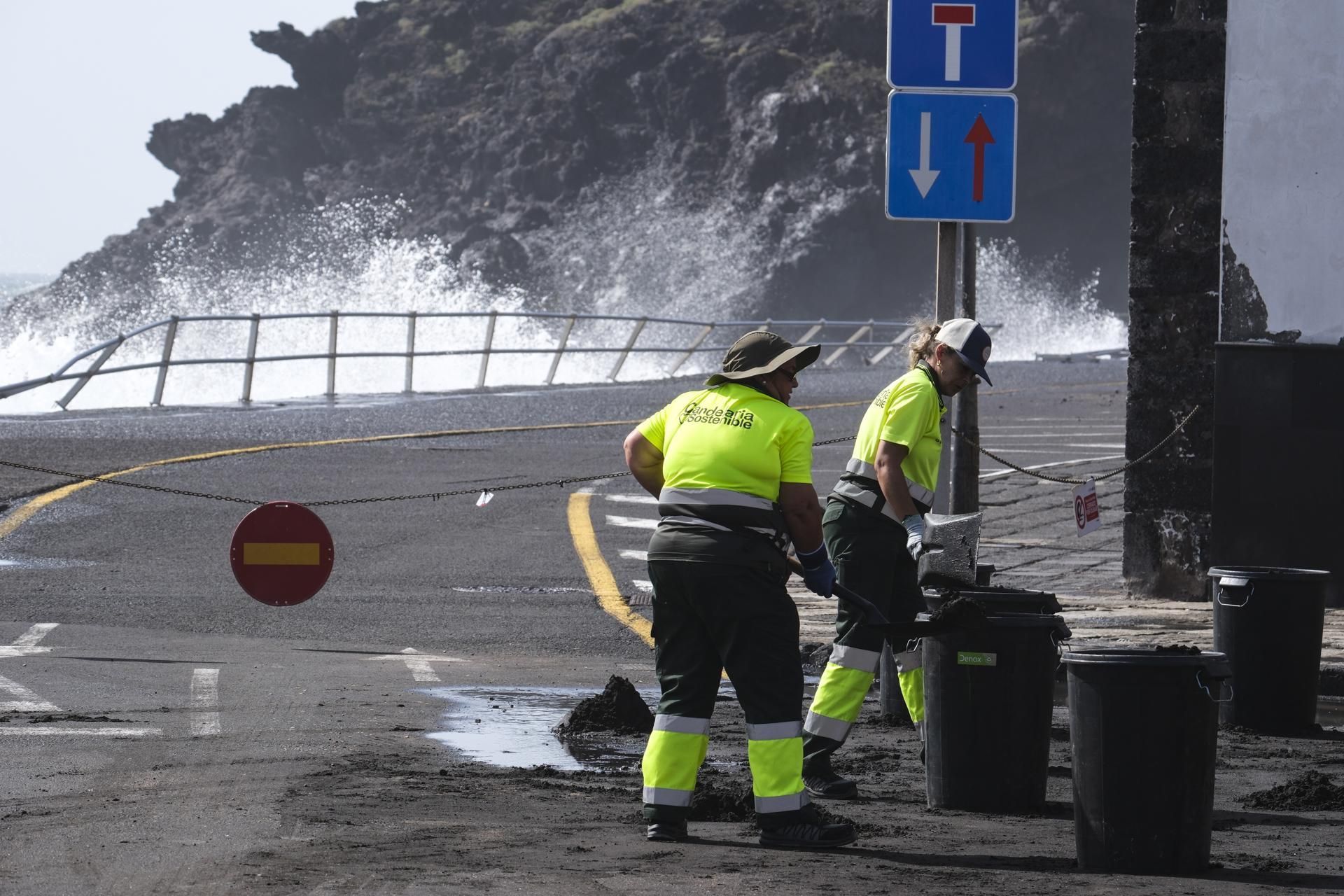 Operarios limpian del destrozos del mar junto a la plaza de la Virgen de Candelaria.