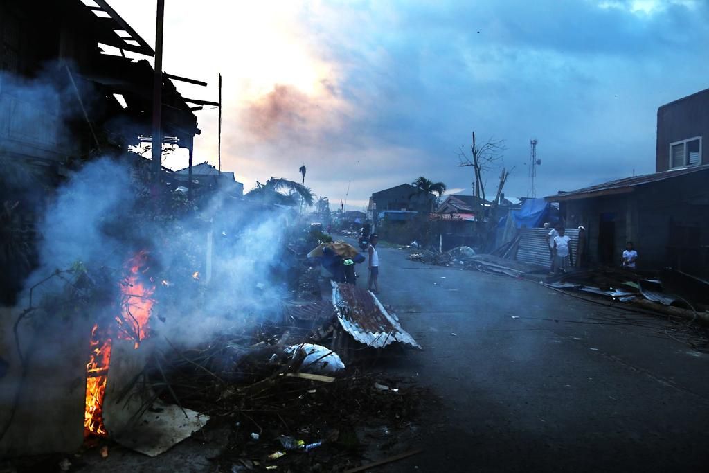 Distrito de Burauen, isla de Leyte “Tanto en Burauen como en otras zonas de la isla de Leyte, los filipinos intentan rehabilitar sus casas devoradas por la tormenta o apuestan por construir nuevas viviendas” describe Agus Morales, periodista de MSF. “Por las tardes, queman los escombros, y una nube tóxica (madera, basura, vegetación) se mezcla en el ambiente con el calor tropical. Parece un rito oriental para que arda todo lo relacionado con el tifón y los hogares y la vida se renueven”. © Agus Morales