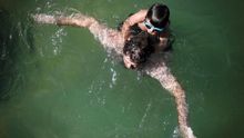 Un hombre y su hijo se bañan este viernes en la playa de La Concha de San Sebastián.