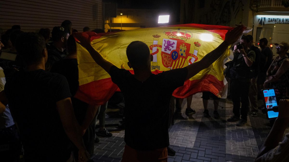 Un manifestante ondea una bandera de España mientras increpa a periodistas este martes en Torre Pacheco (Murcia). EFE/ Pablo Miranzo