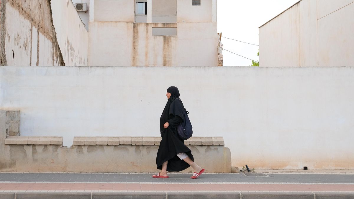 Una mujer camina este lunes por el centro de Torre Pacheco (Murcia), localidad de unos 40.000 habitantes de los que un tercio son inmigrantes de origen magrebí que llevan décadas trabajando sobre todo como peones agrícolas y de almacén.