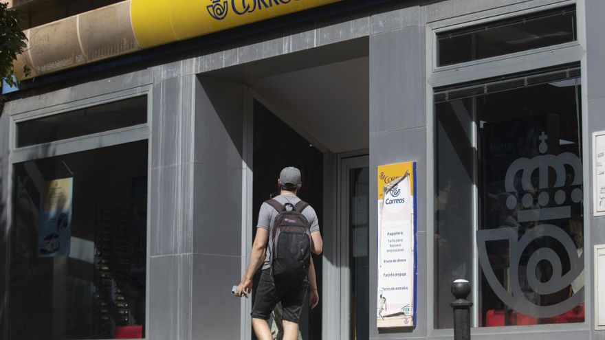 Una persona entra en una oficina de correos. A 17 de julio de 2023, en Sevilla (Andalucía, España).