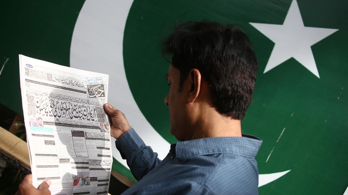 Un hombre lee una noticia sobre el alto el fuego entre Irán y EEUU e Israel en Karachi (Pakistán) el 8 de abril.