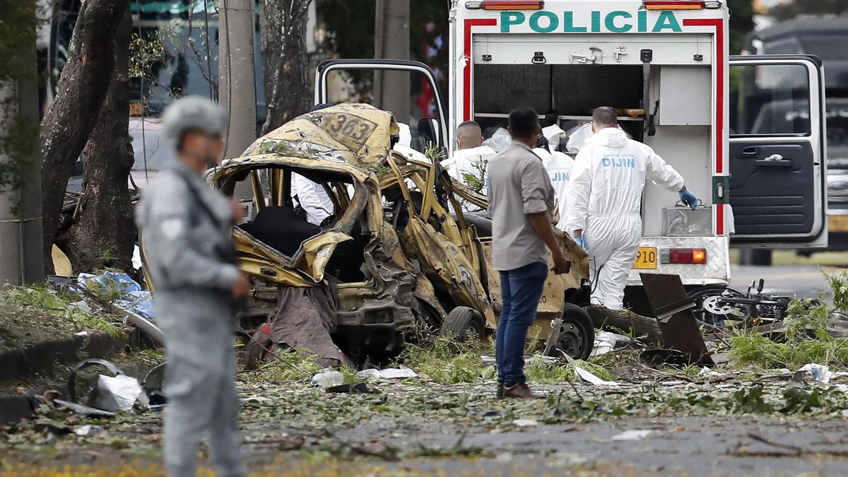 Integrantes de la Dirección de Investigación Criminal e Interpol (DIJIN) inspeccionan un vehículo afectado tras una explosión en inmediaciones de la Escuela Militar de Aviación Marco Fidel Suárez el jueves 22 en Cali (Colombia).