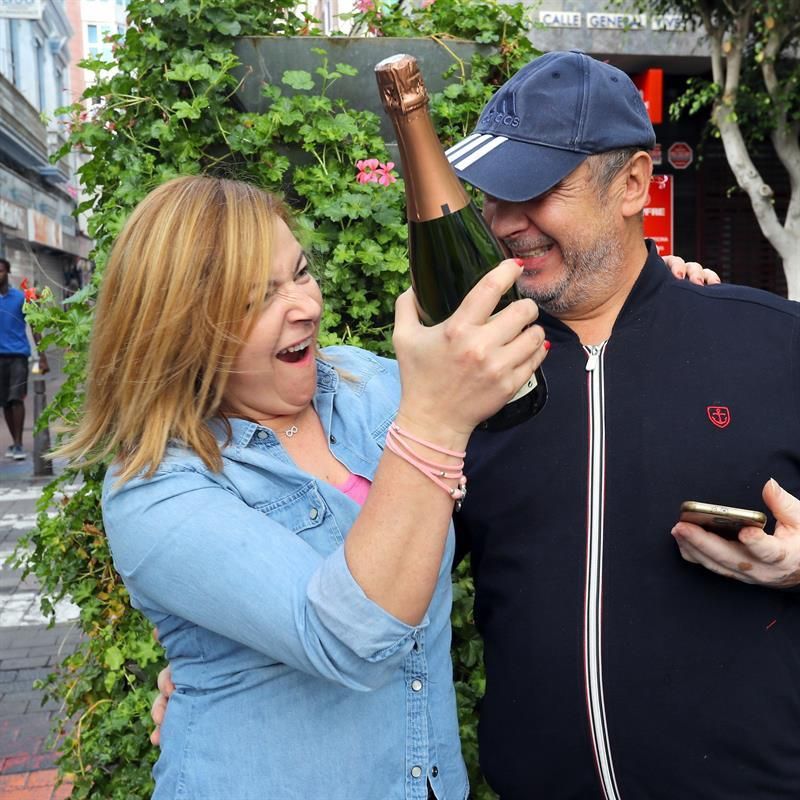 El propietario de la administración de lotería del parque Santa Catalina, Luis Saavedra, y una de sus empleadas celebran los ocho décimos del quinto premio 06293 que han vendido.