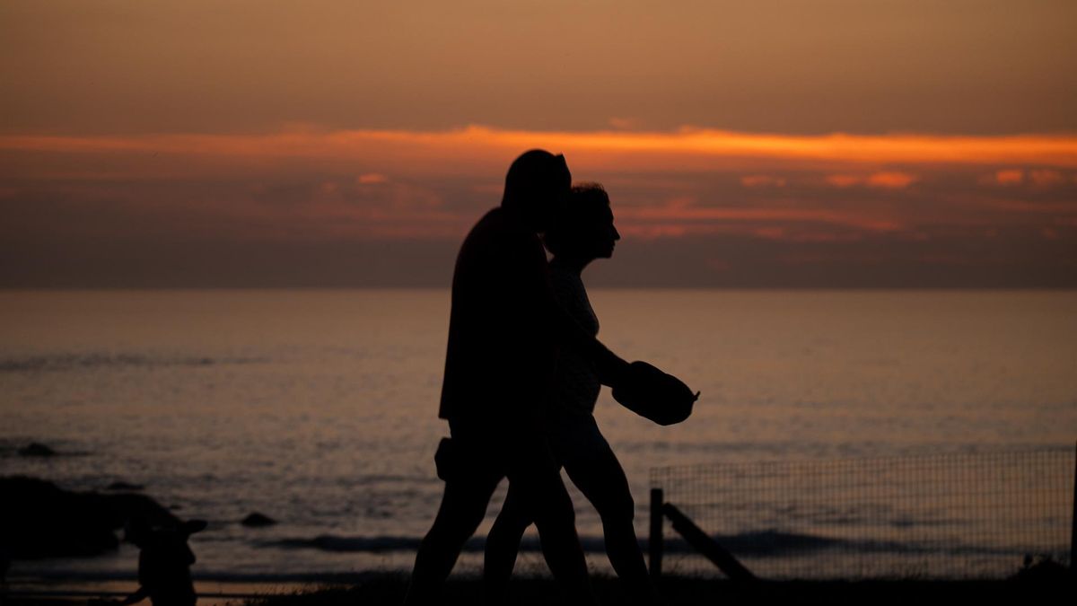 Dos personas pasean por una playa