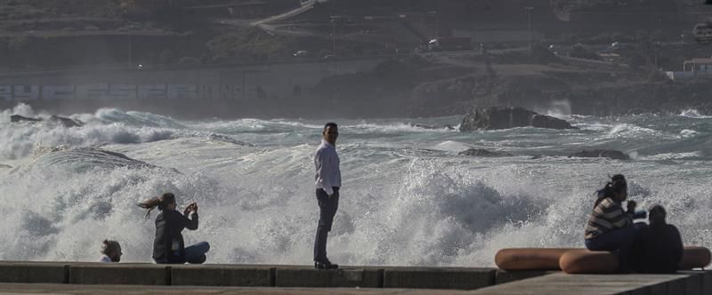 Varias personas observan el oleaje de fondo en el paseo de la playa de Las Canteras en Las Palmas de Gran Canaria. EFE/Elvira Urquijo A.