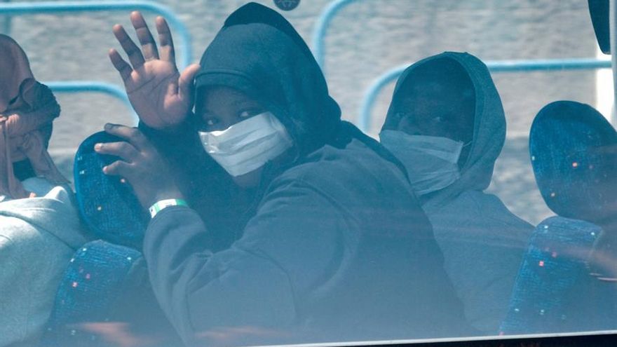 Varias personas son trasladadas en guagua desde el puerto de Arguineguín (Gran Canaria) tras ser rescatadas por Salvamento Marítimo de una patera