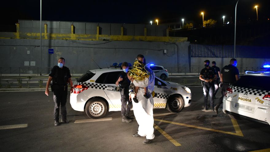 Un hombre migrante junto a policías en Ceuta tras acceder de forma irregular a la ciudad española