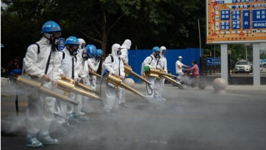 Miembros del equipo del equipo de limpieza de Pekín realizan una desinfección en el mercado mayorista de Yuegezhuang ubicado en la capital china.