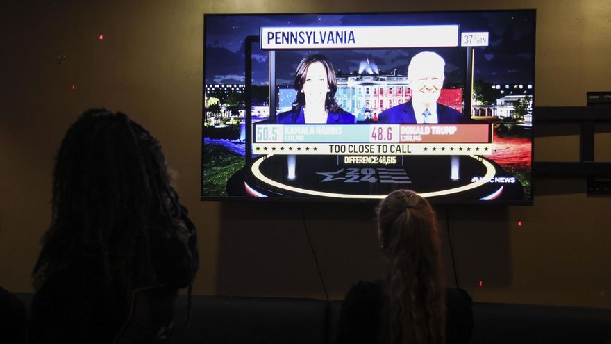 Dos personas siguen los resultados electorales en un local de Nueva York.