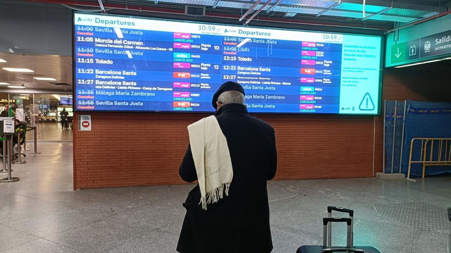 Un viajero mira la pantalla en la que aparecen varios trenes cancelados a Andalucía, en la estación Puerta de Atocha-Almudena Grandes.