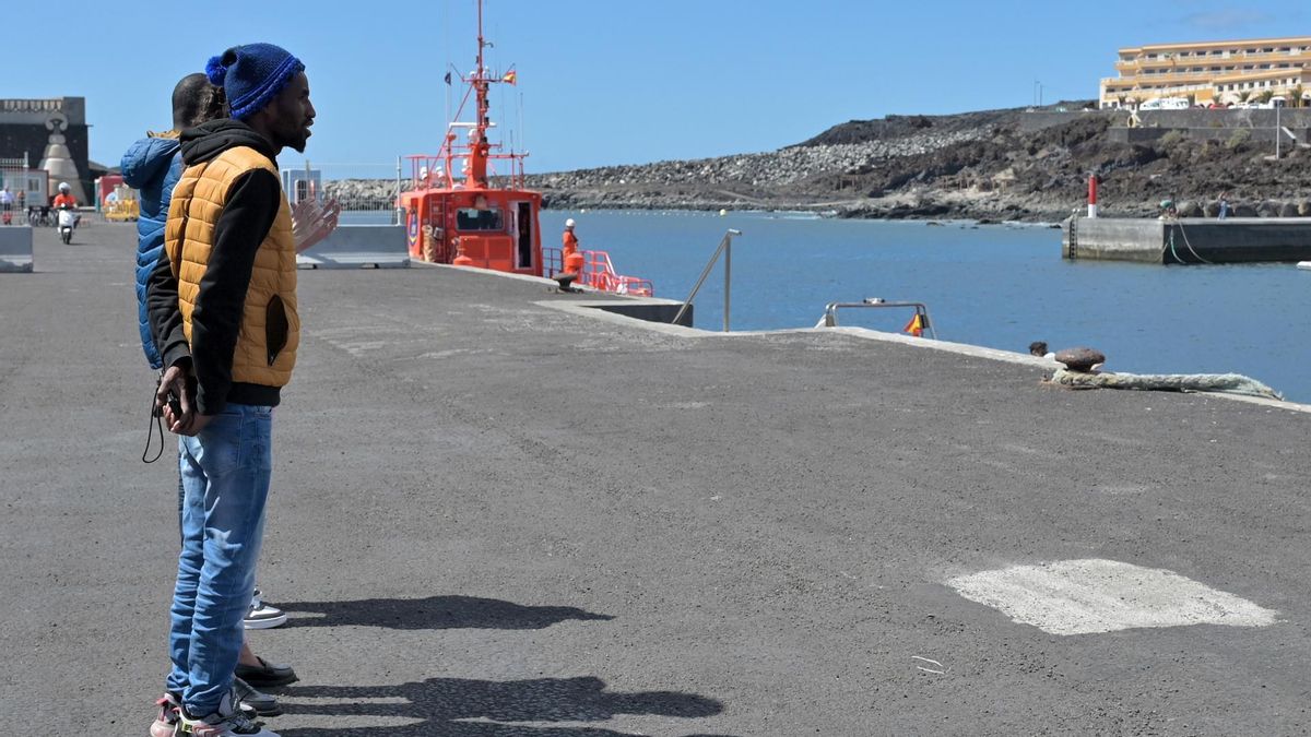 Alkhassoum Sow (i) y Oumar Diallo (d) contemplan los medios de rescate del muelle de La Restinga (El Hierro), tras haber identificado ante la Guardia Civil a uno de sus parientes entre los nueve cuerpos que pudieron recuperarse del naufragio de un cayuco en la isla el 28 de septiembre.