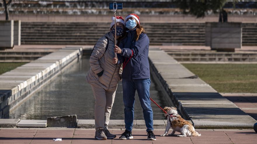 Dos mujeres, con un gorro de Papá Noel, se hacen un selfie en el estadio de Montjuic (Barcelona)