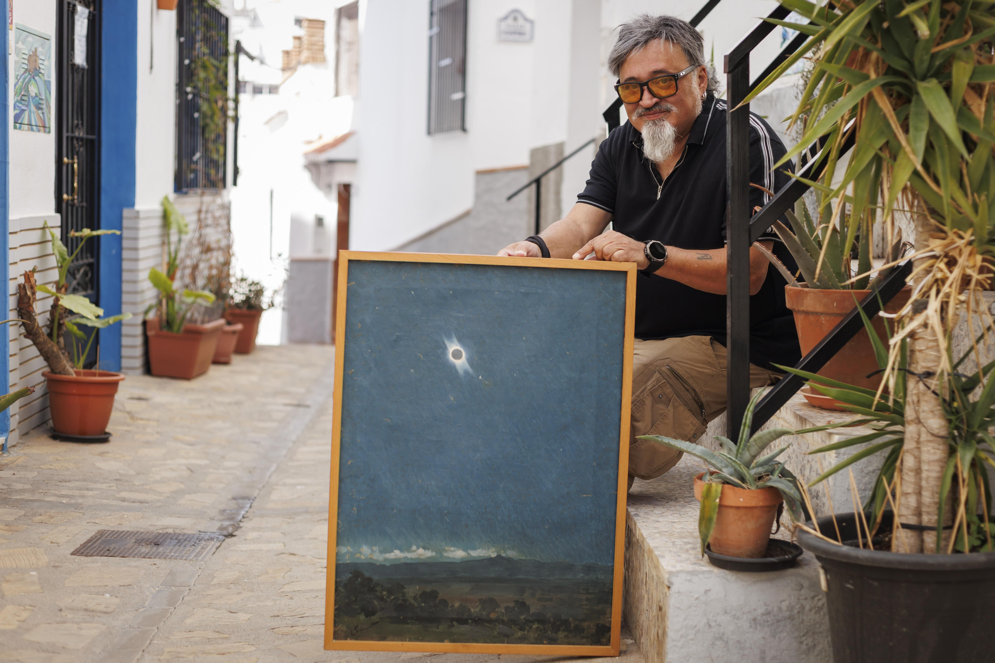 Alfonso Arias posa con el cuadro de Enrique Simonet, su bisabuelo, en el que plasmó el eclipse de 1905 en su casa de Salobreña (Granada).
