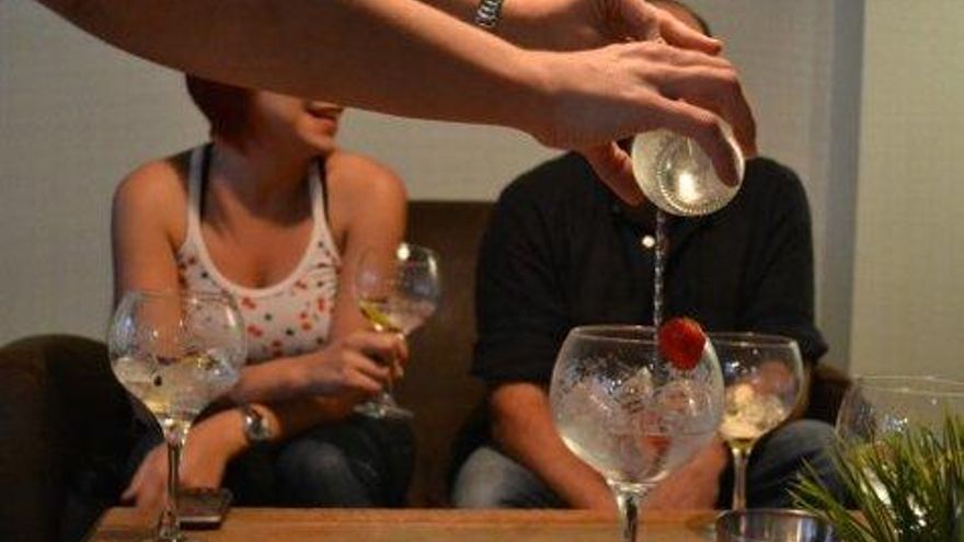 Preparación de un gin tonic con fresas.