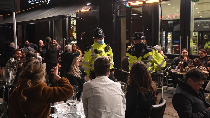 Unos policías conversan con un grupo de jovenes en la terraza de un pub londinense, en el dia de la reapertura de los servicios no esenciales en el Reino Unido. EFE/EPA/FACUNDO ARRIZABALAGA