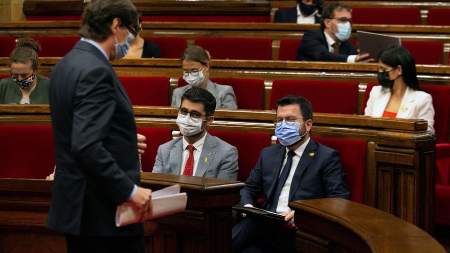 El líder del PSC, Salvador Illa (i), pasa ante el presidente de la Generalitat, Pere Aragonès (d), y su vicepresidente, Jordi Puigneró (i), durante el pleno del Parlament. EFE/Enric Fontcuberta
