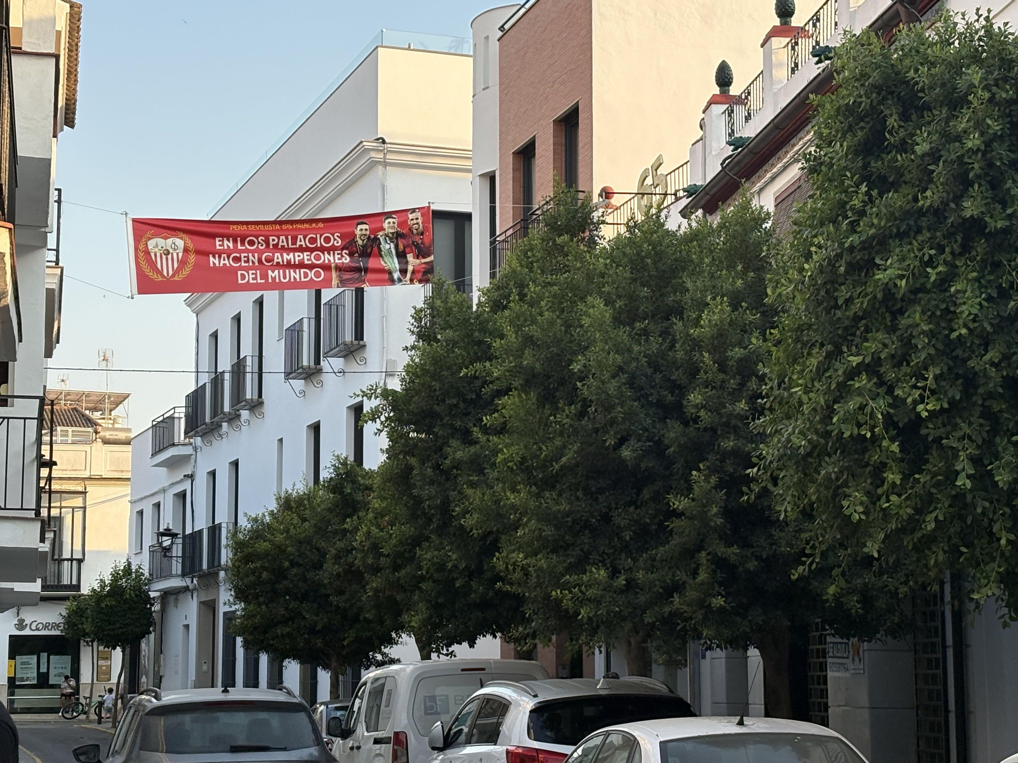 La peña sevillista de Los Palacios reconoce a sus jugadores con una pancarta en plena calle