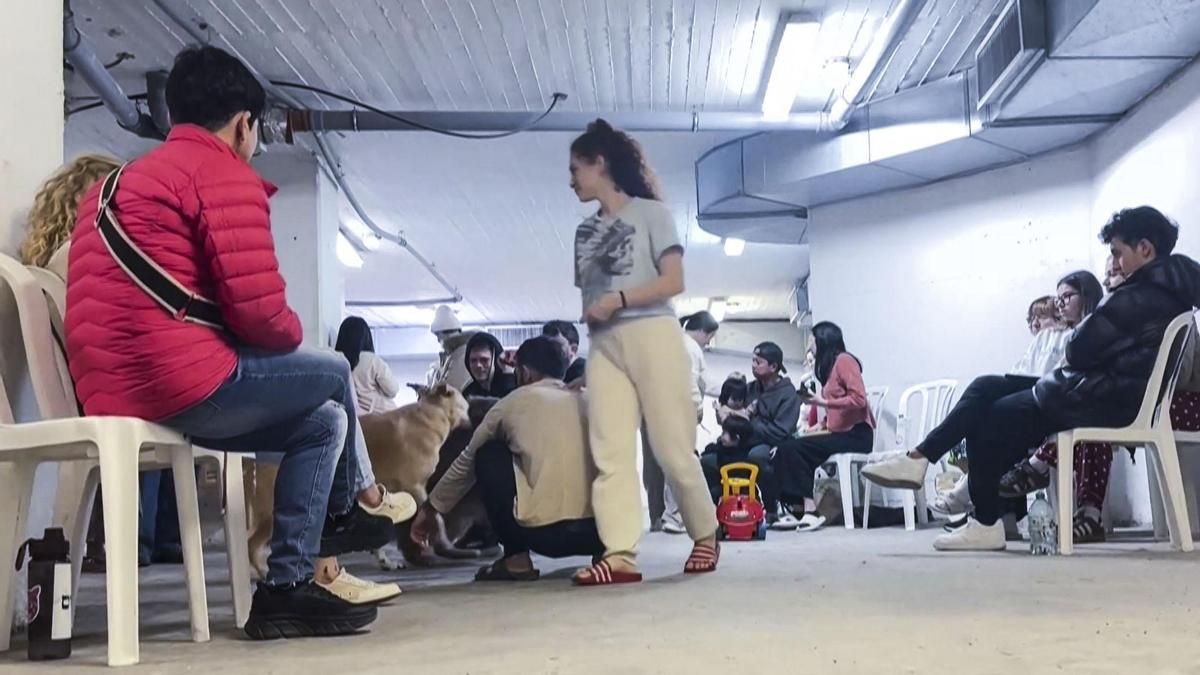 Captura de video de varias personas refugiadas en un búnker mientras suenan las alarmas antiaéreas este sábado en Jerusalén.