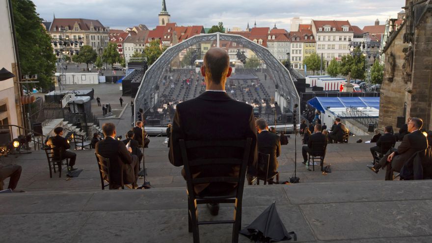 Los cantantes se sientan muy separados durante un ensayo de concierto frente a la iglesia Mariendom y St Severus.