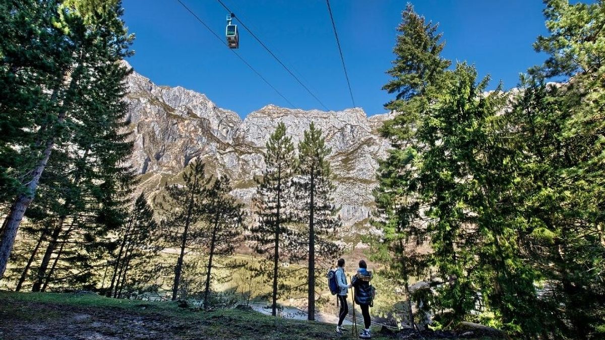 Dos montañeros observan el teleférico de Fuente Dé.