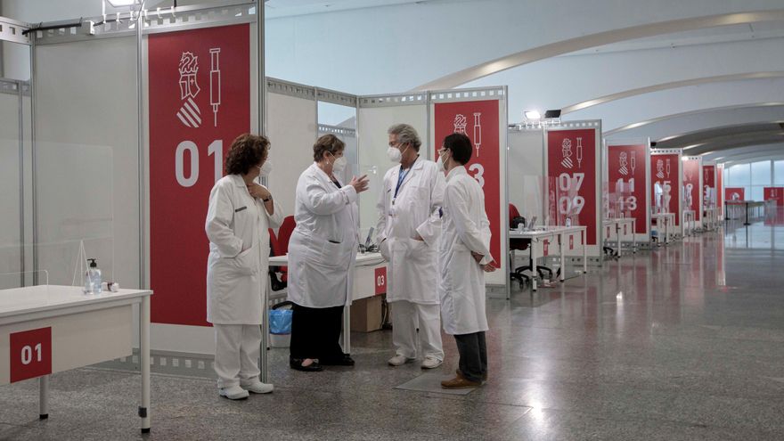 Varios sanitarios conversan este sábado en el punto de vacunación masiva de Valencia situado en la Ciudad de las Artes y las Ciencias. EFE/Biel Aliño
